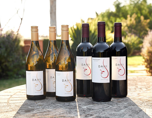 Six bottles of wine; 3 white, 3 red displayed outside