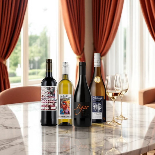 Wine bottles on a marble table with red curtains in the background