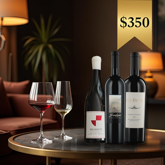 A set of three wine bottles on a table with two glasses of red wine, featuring a gold medal wine club branded steel corkscrew and black foil cutter.