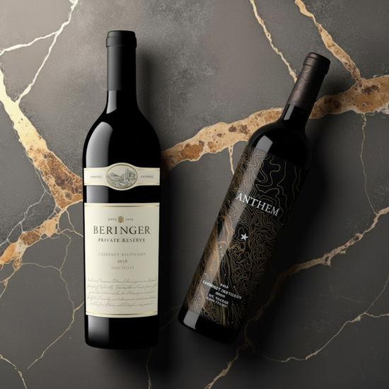 Two wine bottles, one labeled 'Beringer' and the other 'Anthem', on a marble surface.