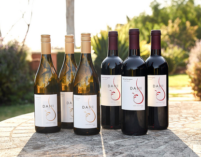 six bottles of wine, 3 white & 3 red, displayed outside