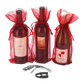 Three bottles of wine in red sheer gift bags next to wine tools